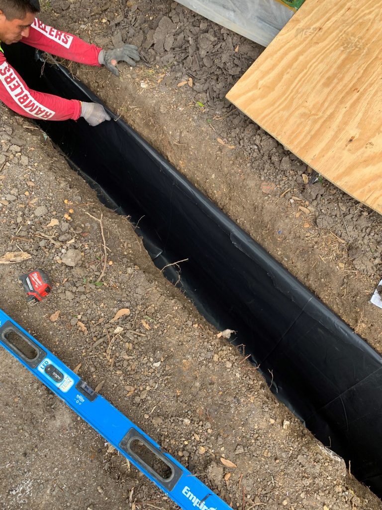 trench along exterior of the property to repair drainage