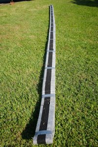 Hydraway drainage strip displayed on lawn before installation to improve foundation and yard water flow.